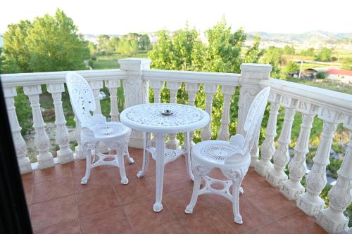a white table and two chairs on a balcony at Hotel Onufri in Golem