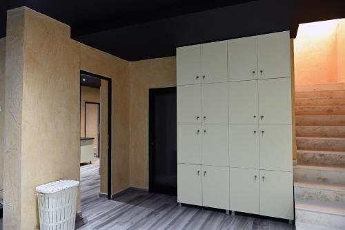 a room with white cabinets and a staircase at Hotel Onufri in Golem