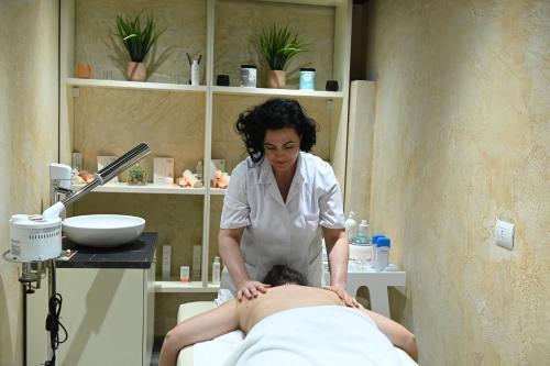 a woman in a spa giving a man a massage at Hotel Onufri in Golem