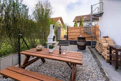 a patio with a wooden table and a grill at DARFATI 4-Zimmer Wohnung in Pliening