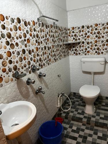 uma casa de banho com um lavatório e um WC em Hotel Shivanand em Siliguri