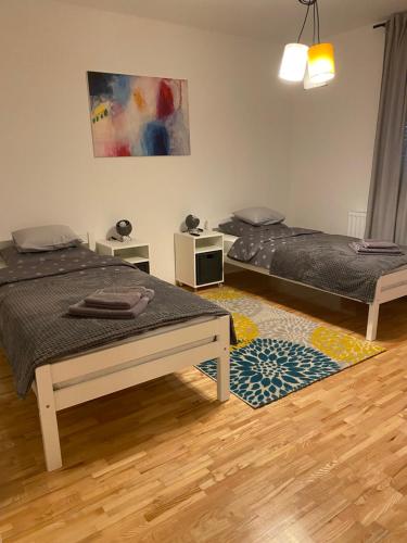 een kamer met 2 bedden en een tapijt bij LEGA-LEGA in Osijek