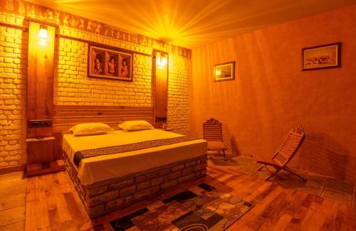 a bedroom with a bed and a brick wall at BluSalzz Homes - The Himalayan Bungalow, Almora - Uttarakhand in Almora