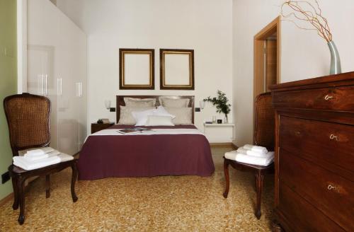 a bedroom with a bed with two chairs and a mirror at Residenza Roccamaggiore in Verona