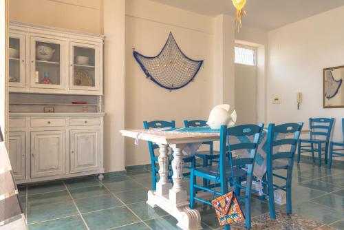 a dining room with blue chairs and a table at Dimore di mare - Beachfront Apartments in Santa Flavia