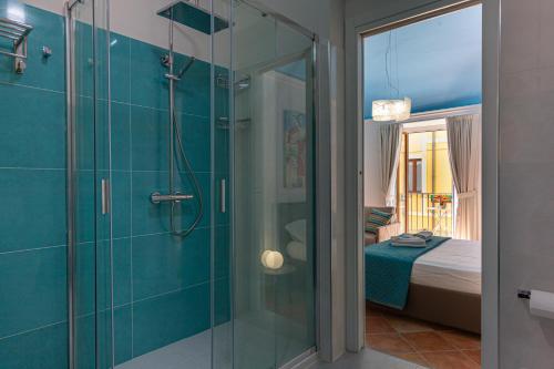 a bathroom with a glass shower with a bed at CATHENA HOLIDAY CEFALU in Cefalù