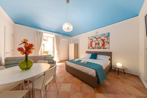 a bedroom with a bed and a table and a couch at CATHENA HOLIDAY CEFALU in Cefalù