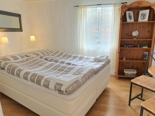 a large bed in a room with a window at Aline's Stue, B&B Utskarpen in Fuglstad