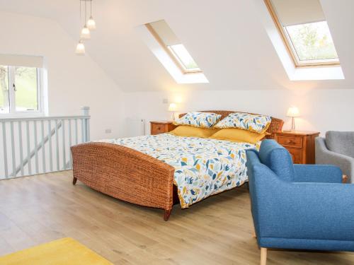 a bedroom with a bed and a blue chair at Gerry's Place in Church Stretton