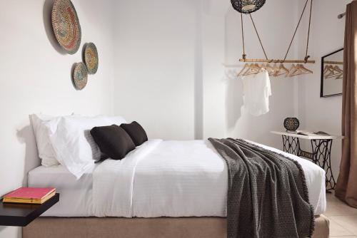 Un dormitorio con una cama con sábanas y almohadas blancas. en Casa Bu, en Fira