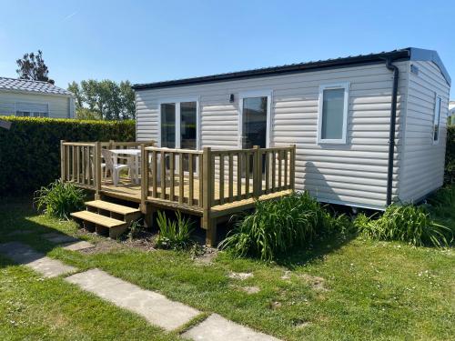 a tiny house with a porch and a bench at Camping Le Tarteron in Le Crotoy