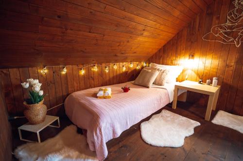 una camera con letto in una stanza in legno con luci di Beautiful Wooden House with Jacuzzi - Chalet Hisa Karlovsek a Šmarješke Toplice