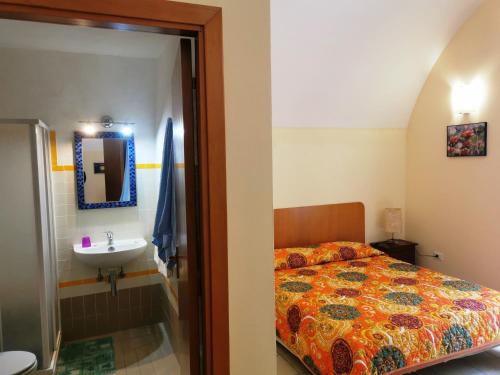 1 dormitorio con cama y lavamanos en Bed & Breakfast Alba, en Noto