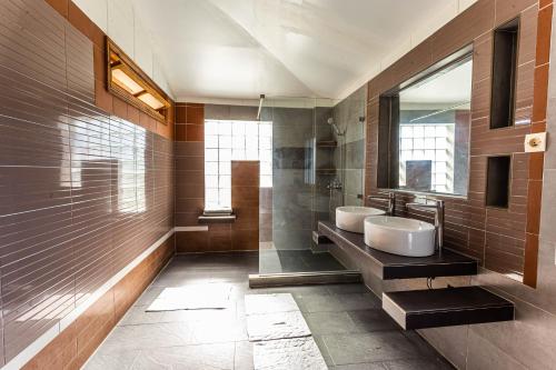La salle de bains est pourvue de 2 lavabos et d'un miroir. dans l'établissement Eulophiella, à Andasibe