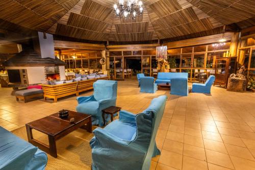 a large lobby with blue chairs and a table at Eulophiella in Andasibe
