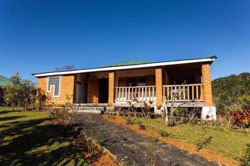 a brick house with a porch and a balcony at Eulophiella in Andasibe