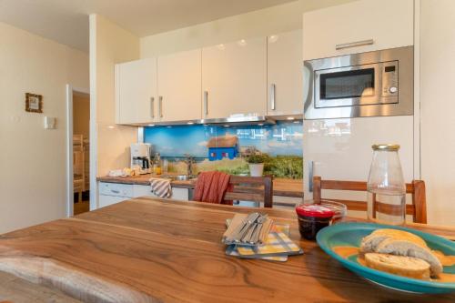 una cucina con un tavolo di legno con un piatto di pane di Aquamarina 17 a Heiligenhafen