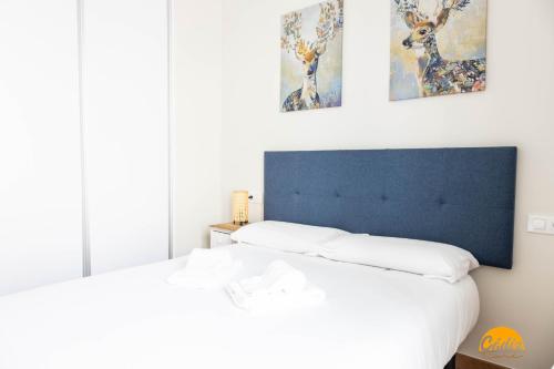 1 dormitorio con 2 camas y 3 pinturas en la pared en Nature Home by Cadiz Time, en Cádiz