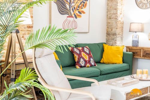 un sofá verde en una sala de estar con plantas en Nature Home by Cadiz Time, en Cádiz