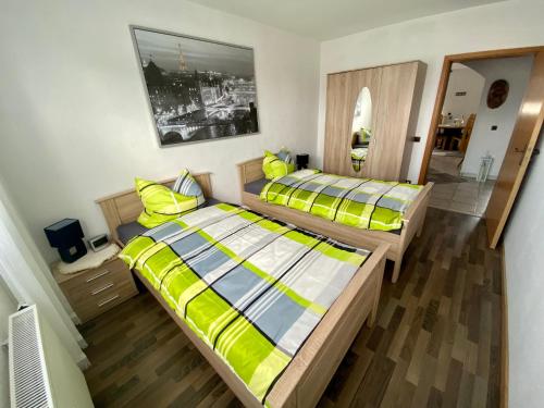 two beds in a room with yellow and blue at Apartment Anita in Bottrop