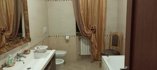 bagno con lavandino, servizi igienici e specchio di B&B CASA NISI a Villa Castelli