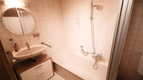 a bathroom with a tub and a sink and a shower at Pension Eichertstüberl in Furth im Wald