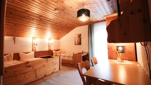 a living room with a wooden ceiling and a table at Pension Eichertstüberl in Furth im Wald