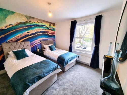 a bedroom with two beds and a rainbow mural at Beautiful & Vibrant City Centre House in Canterbury