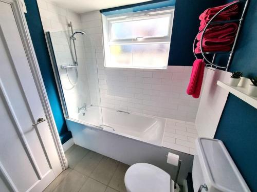 uma casa de banho com uma banheira, um WC e um lavatório. em Beautiful & Vibrant City Centre House em Canterbury