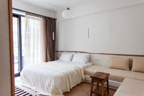 a bedroom with two beds and a couch at Alex & Sofi Apartments in Himare