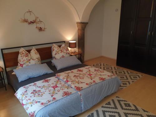 1 dormitorio con 1 cama con colcha de flores en Ferienwohnung Bärnham en Babensham