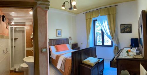 a bedroom with a bed and a bathroom at B&B Domus Deiana in Mamoiada