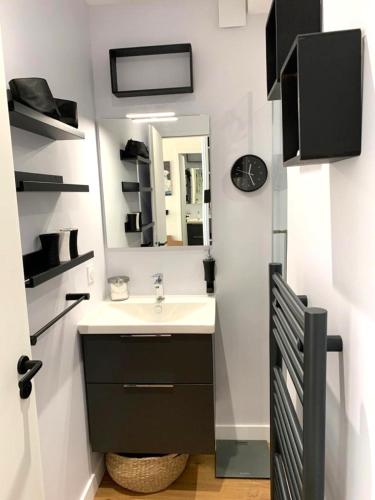 une salle de bain avec un lavabo et un miroir dans l'établissement Les pieds dans l'eau, à Les Sables-dʼOlonne