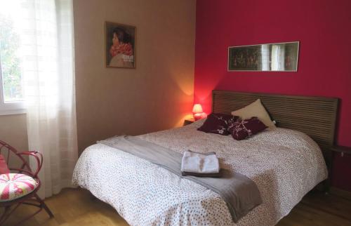sypialnia z dużym łóżkiem z czerwonymi ścianami w obiekcie DUNE & OCEAN w mieście Le Haillan