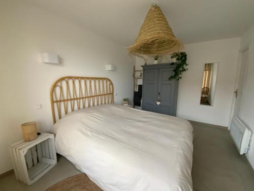 a bedroom with a large white bed in a room at Charmant gîte avec jacuzzi privatif in Saint-Martin-Choquel