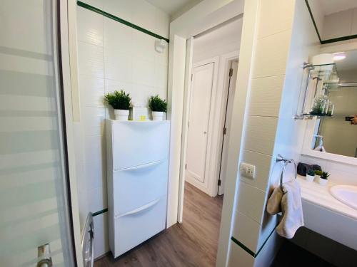 a bathroom with a white refrigerator and a sink at Parque Golf 16 by SunHousesCanarias in Maspalomas