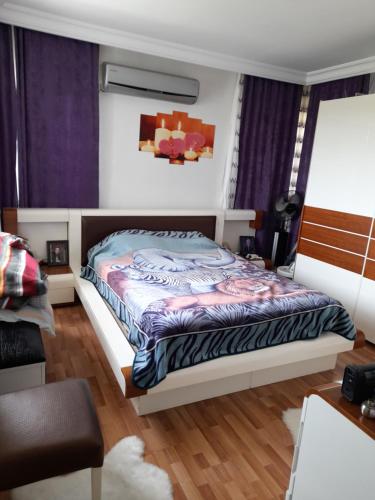 een slaapkamer met een bed met paarse gordijnen bij Lara holiday in Antalya