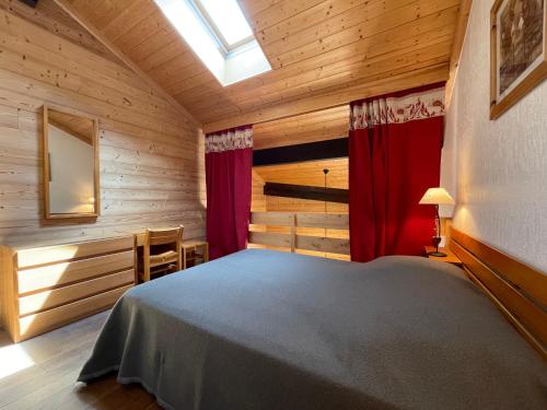 une chambre avec un lit dans une cabane en bois dans l'établissement Crystal 25 - Duplex centre village, à La Clusaz