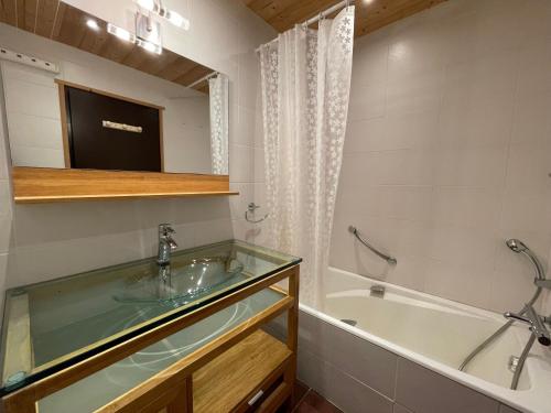 une salle de bain avec une baignoire et un lavabo et une baignoire dans l'établissement Crystal 25 - Duplex centre village, à La Clusaz
