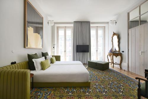a bedroom with a large bed and a couch at Cais Urban Lodge in Lisbon