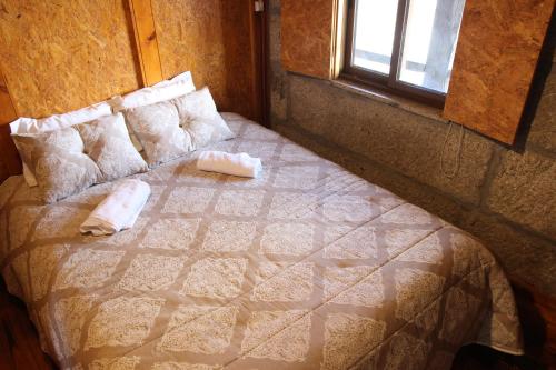 a bedroom with a bed with pillows and a window at Casa Viade in Montalegre