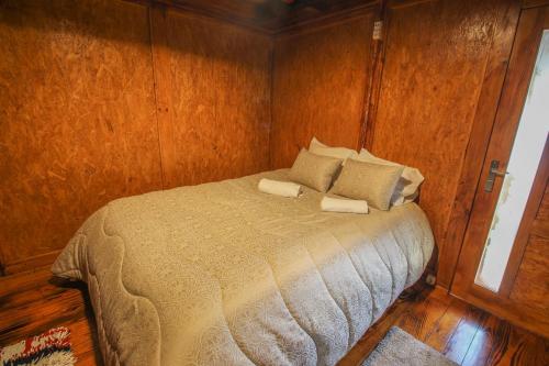 a bedroom with a bed in a wooden wall at Casa Viade in Montalegre
