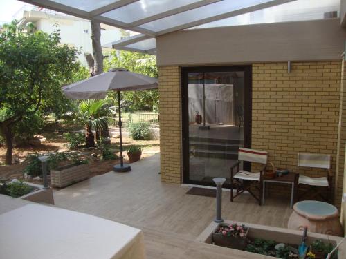 a patio with an umbrella and a table and chair at Amazing Garden House in Athens
