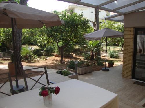 a table with a vase of flowers on it with an umbrella at Amazing Garden House in Athens
