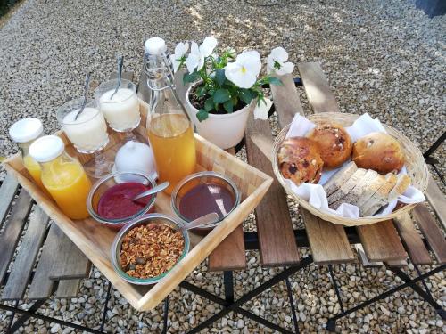 una mesa de picnic con comida para desayunar y bebidas. en La Roulotte du Herdal, en Profondeville