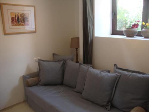 a couch with pillows in a living room with a window at Amazing Garden House in Athens