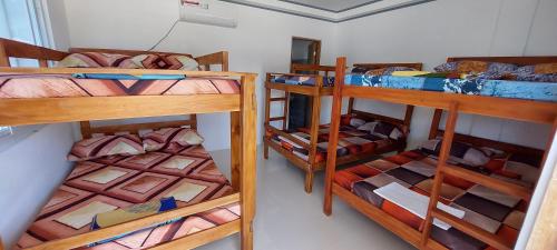 a room with three bunk beds in a room at JCALM Beach resort in Bulala