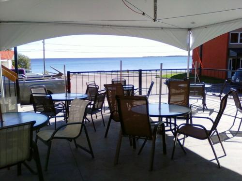 a group of tables and chairs with a view of the ocean at Motel Castille in Roberval