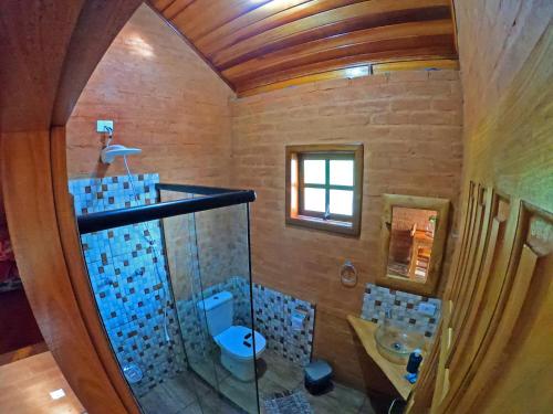 uma casa de banho com um lavatório, um WC e um espelho. em Pousada Lua Bonita em São Bento do Sapucaí