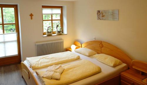 a bedroom with two beds and a cross on the wall at Haus Binderschuster in Unken